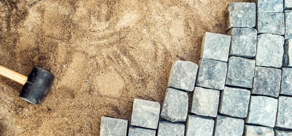 Construction tools and details, pavement installing and rocks. Granite stones laying on sand, making of pavement